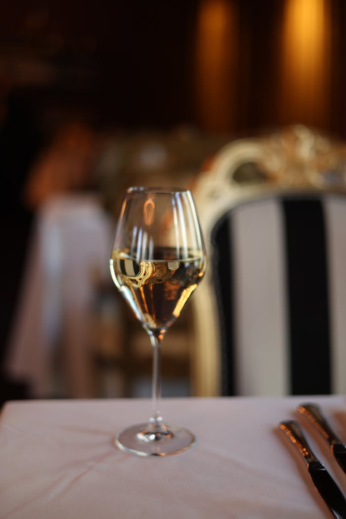 A sophisticated champagne glass on a lavishly set table in a luxurious restaurant.